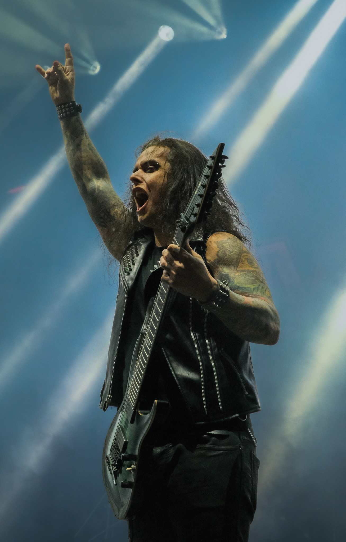 Sahne ışıkları altında gitarını tutan müzisyen